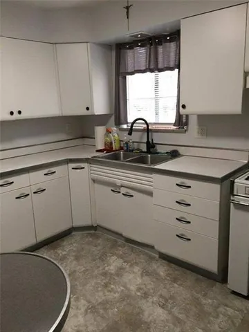 a kitchen with sink window and cabinets