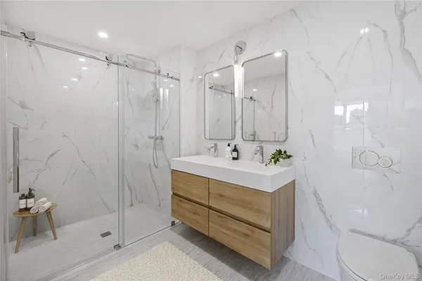 a bathroom with a sink a toilet and shower