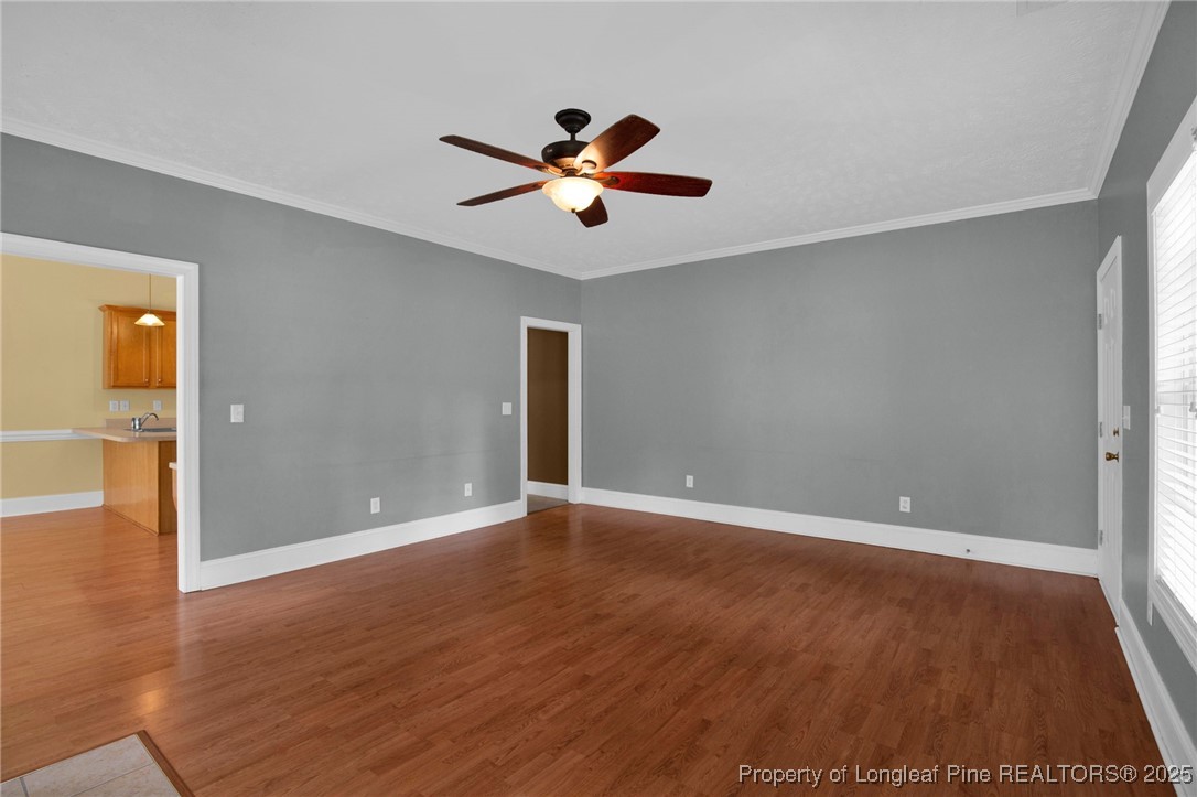 121 Shell Drive Elizabethtown, NC 28337 - Photo 9 of 36 an empty room with wooden floor chandelier fan and windows