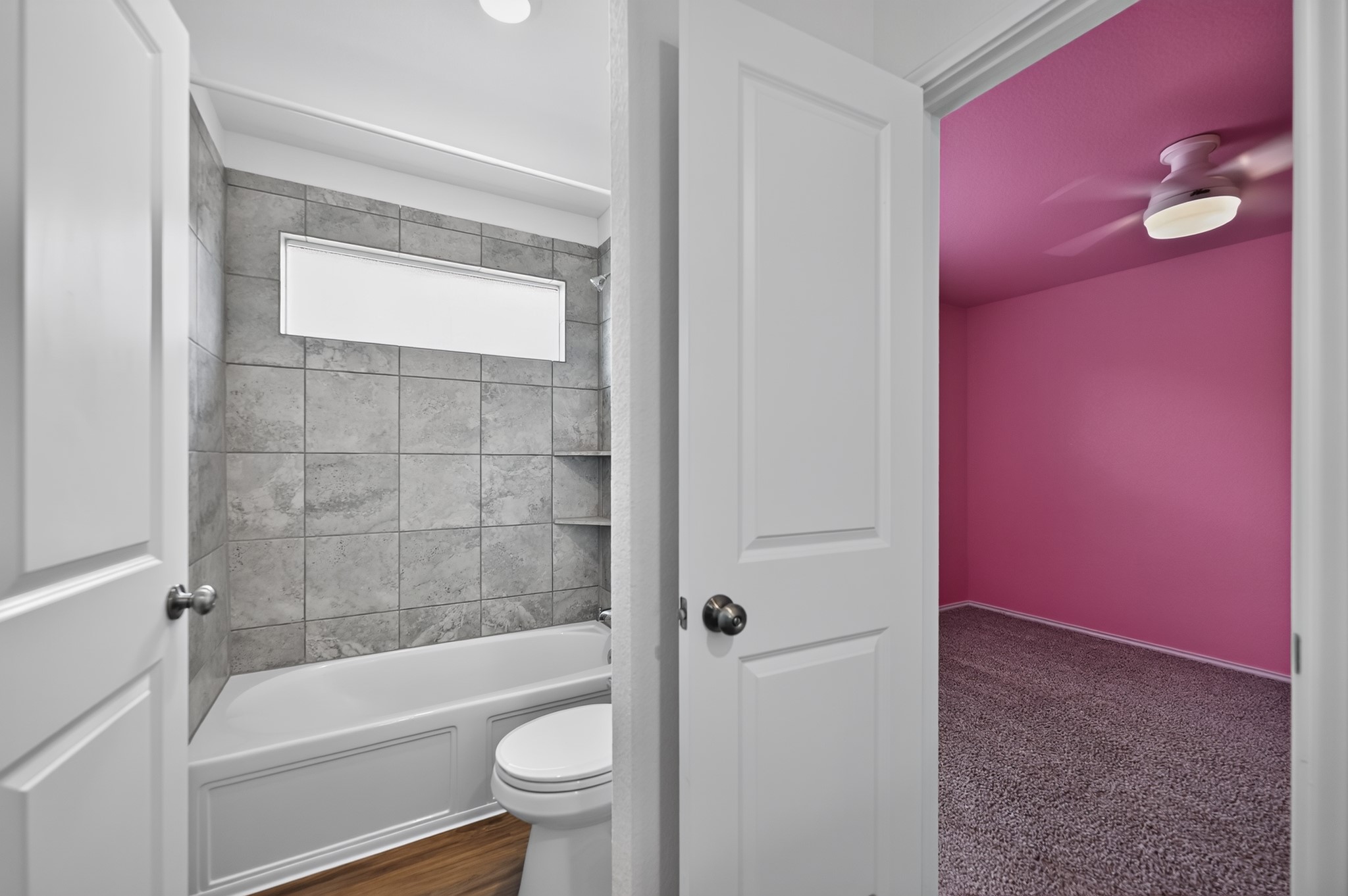 128 Konik Road Georgetown, TX 78626 - Photo 18 of 34 Functional full bathroom with shower and tiled walls sits across from a cozy carpeted room.