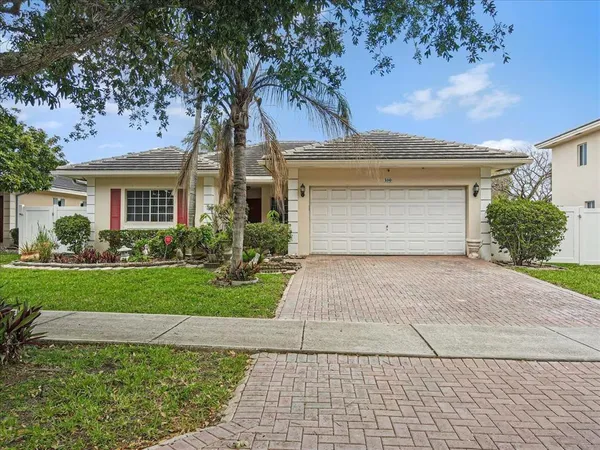 a front view of a house with a garden and plants