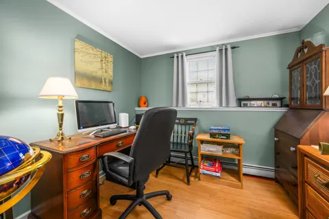 a view of a workspace with furniture and a window
