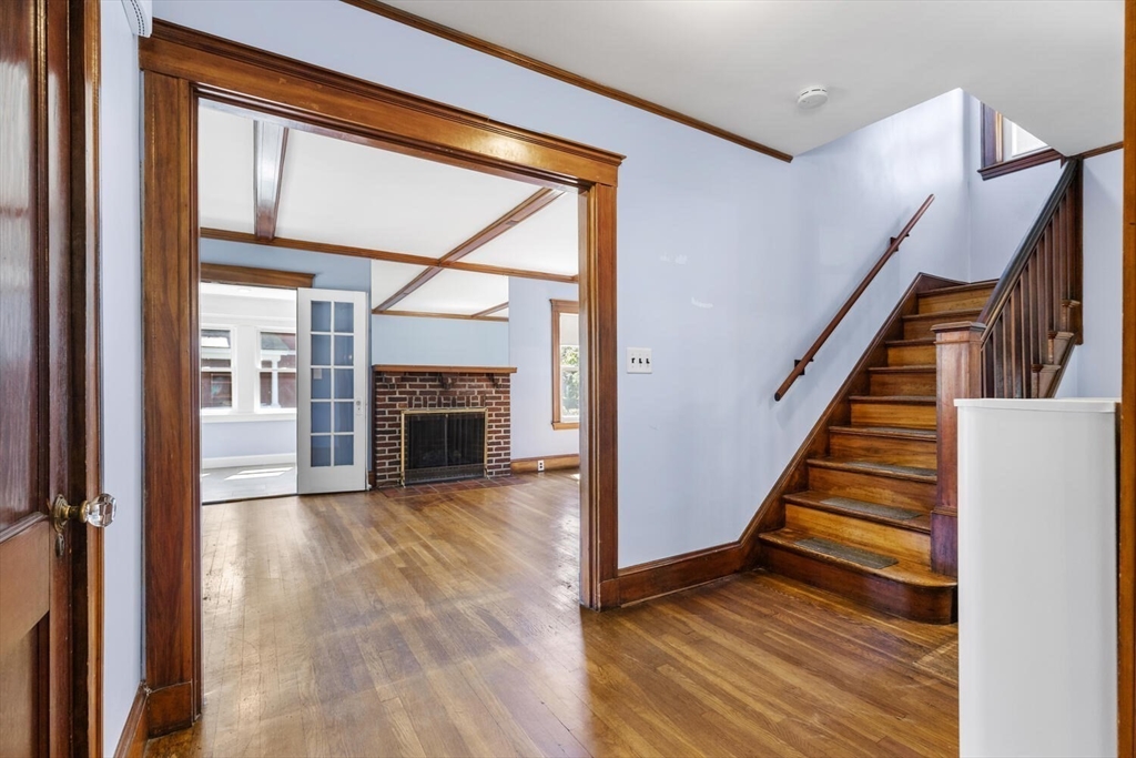 20 Marion Road Watertown, MA 02472 - Photo 5 of 33 a view of a hallway with wooden floor fireplace and a living room