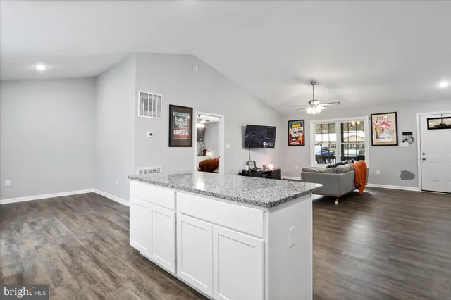 a view of living room with granite countertop furniture and wooden floor
