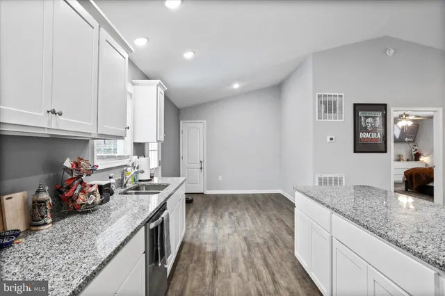 a kitchen with granite countertop lots of counter top space and wooden floor