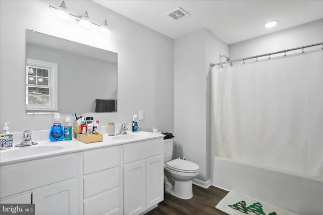 a bathroom with a sink mirror vanity and toilet