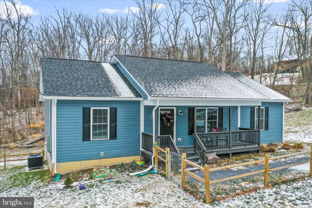 a view of a house with a large window and wooden fence