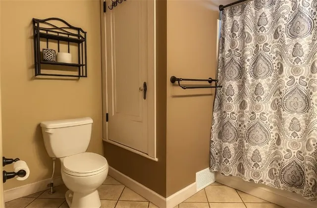 a bathroom with a toilet and a shower curtain