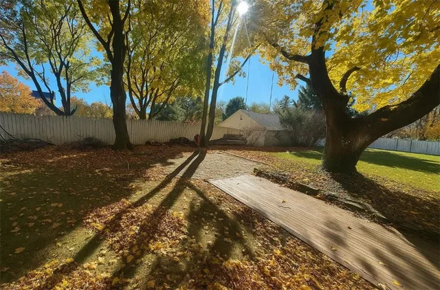 a view of a backyard with wooden fence