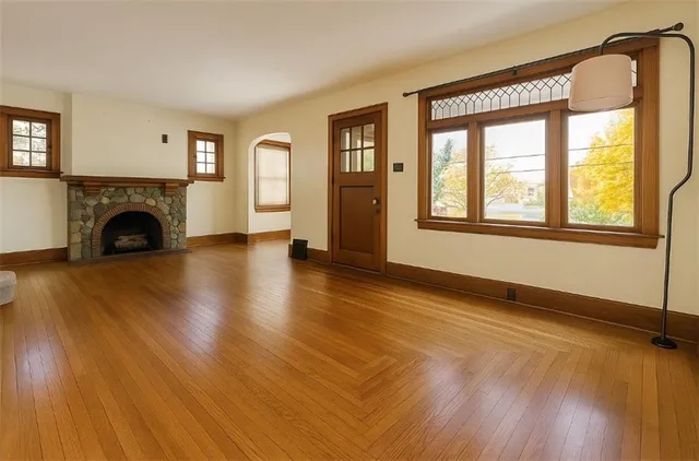 a view of empty room with fireplace and wooden floor