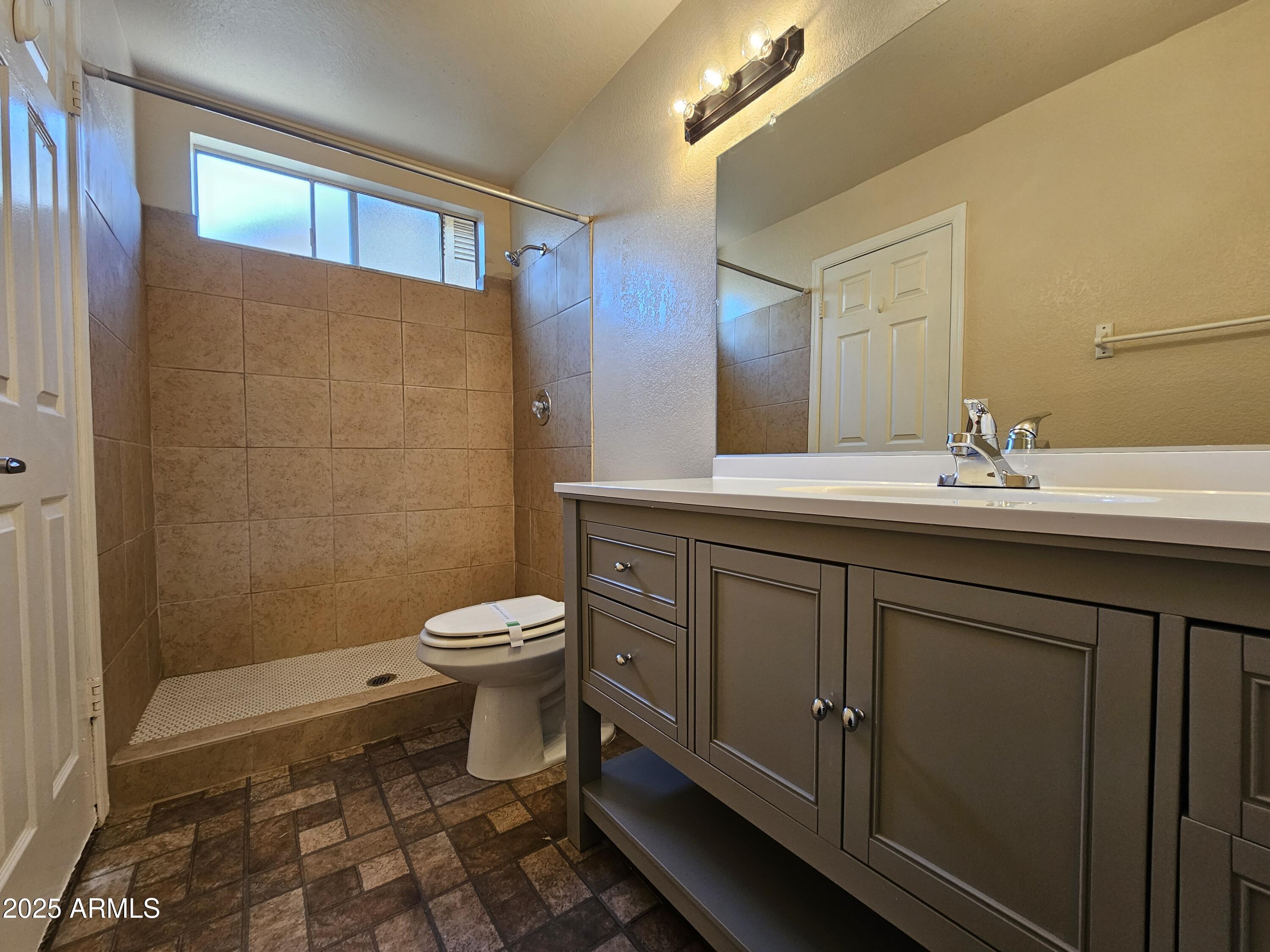 5523 West Yucca Street Glendale, AZ 85304 - Photo 13 of 18 a bathroom with a sink a toilet and mirror