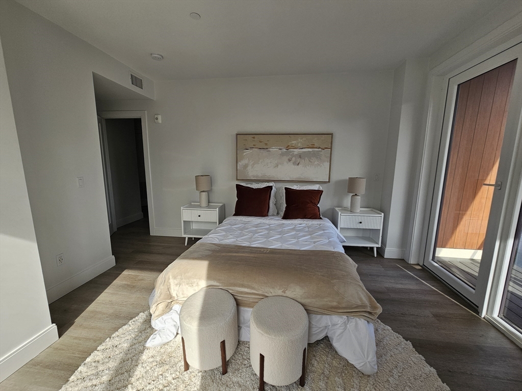 64 Alpine Street, Unit 304 Boston, MA 02119 - Photo 12 of 23 a bedroom with a bed and a mirror