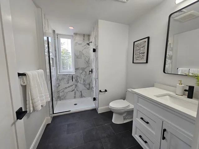 a bathroom with a sink a toilet and shower