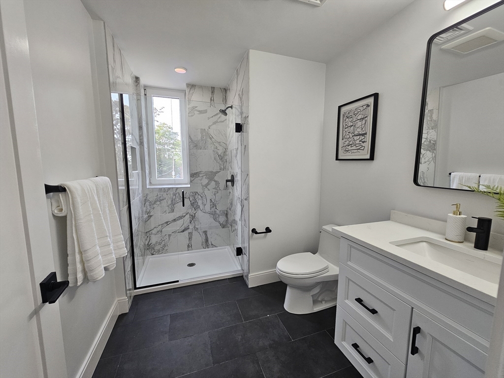 64 Alpine Street, Unit 304 Boston, MA 02119 - Photo 16 of 23 a bathroom with a sink a toilet and shower