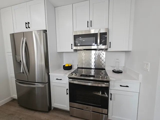a kitchen with stainless steel appliances a refrigerator stove and microwave