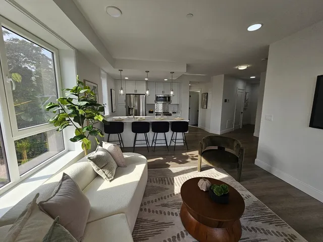 a living room with furniture a chandelier and a fireplace
