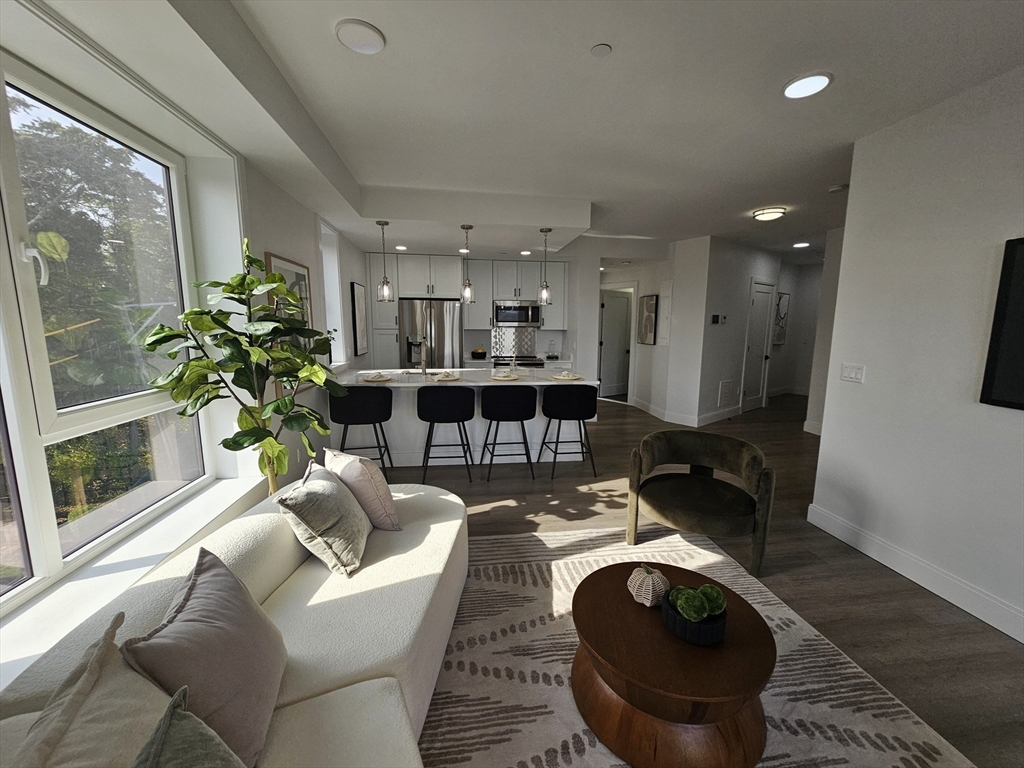 64 Alpine Street, Unit 304 Boston, MA 02119 - Photo 5 of 23 a living room with furniture a chandelier and a fireplace