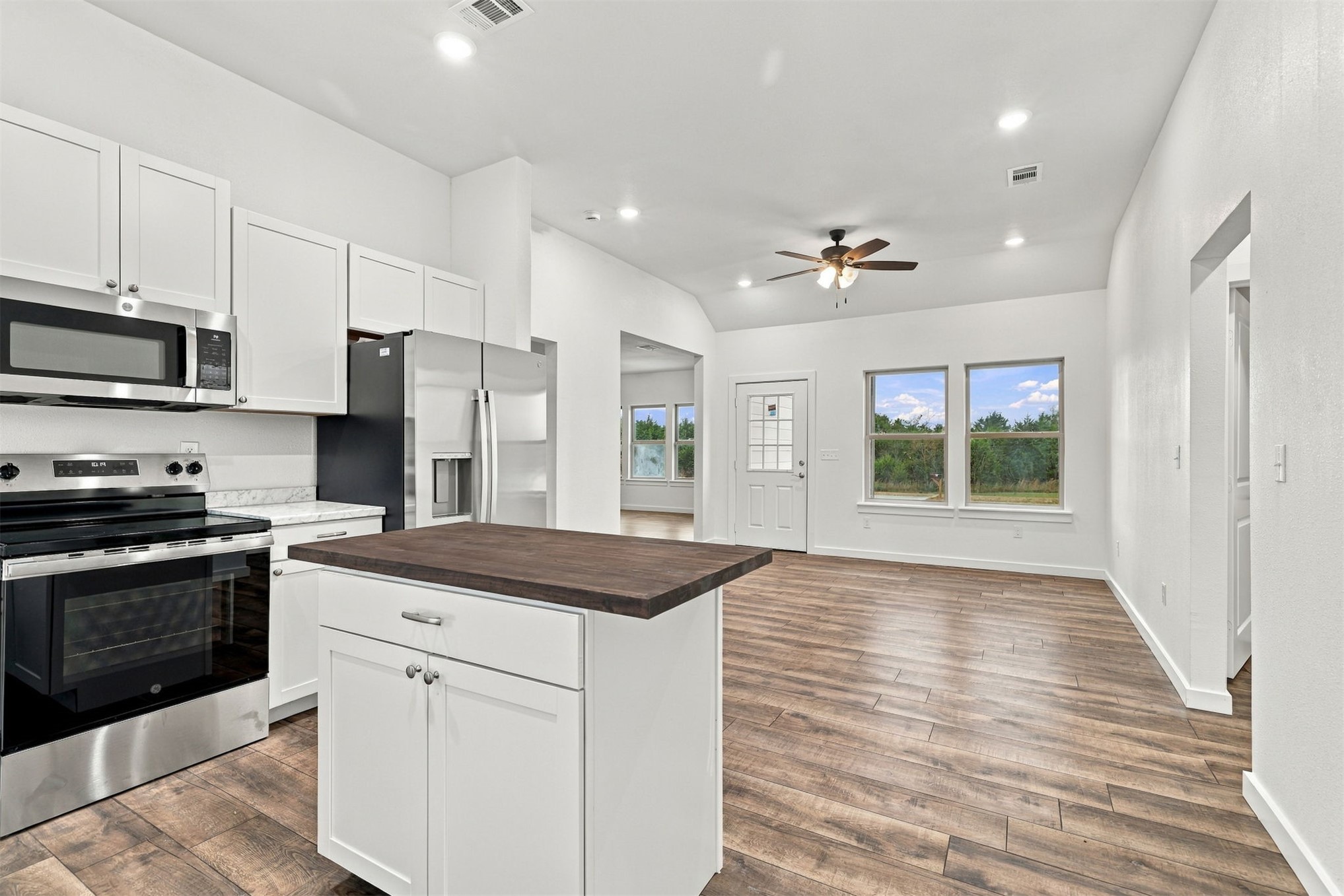 21 Redbird Lane Colbert, OK 74733 - Photo 4 of 27 Kitchen with white cabinetry, stainless steel appliances, and a central island featuring a dark wood-finish countertop