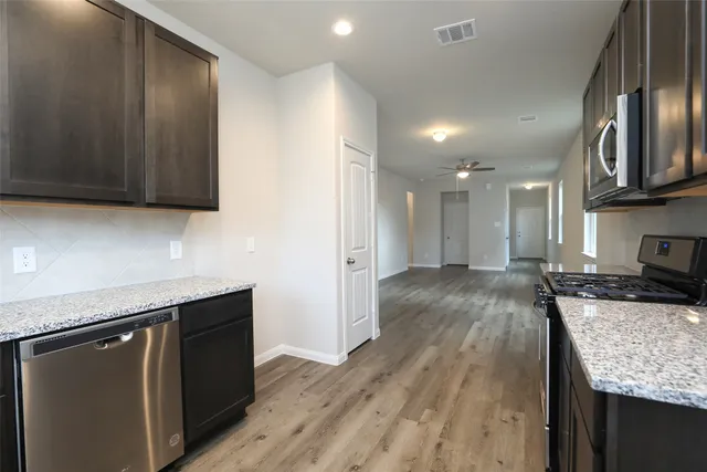 a kitchen with stainless steel appliances granite countertop a sink stove and refrigerator
