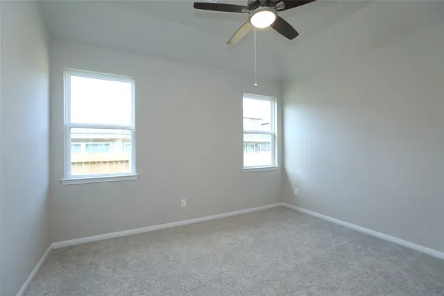 an empty room with a window and a fan