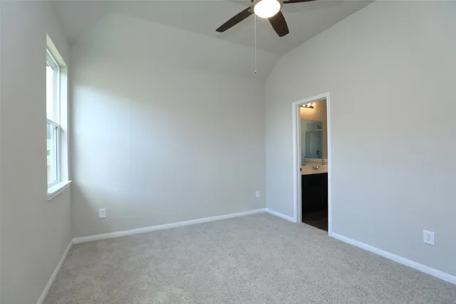 an empty room with ceiling fan and window