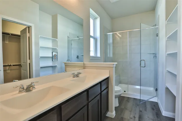 a bathroom with a sink a toilet and shower