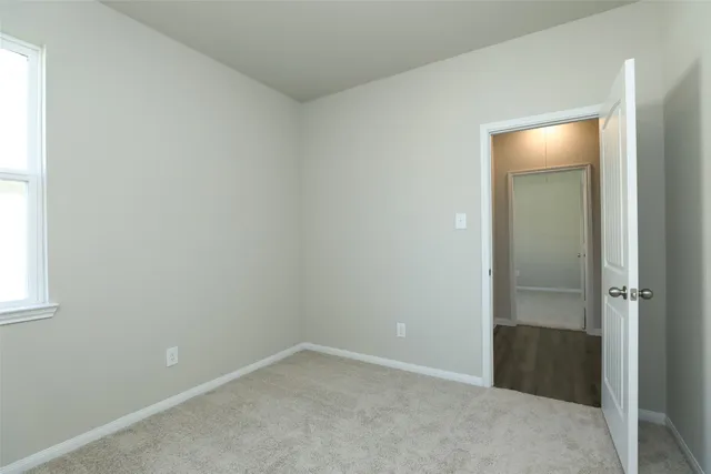 an empty room with closet and mirror