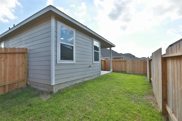 a view of a backyard with wooden fence