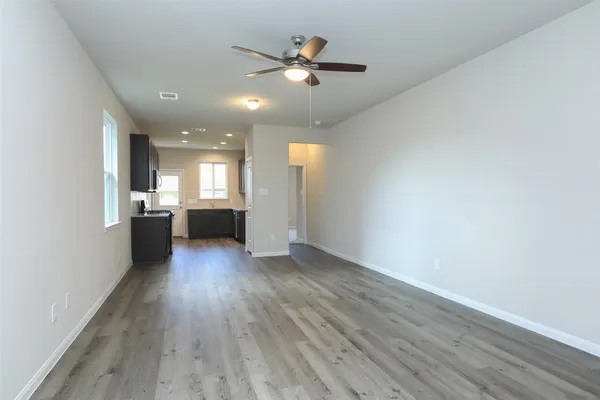 a view of an empty room and window with wooden floor