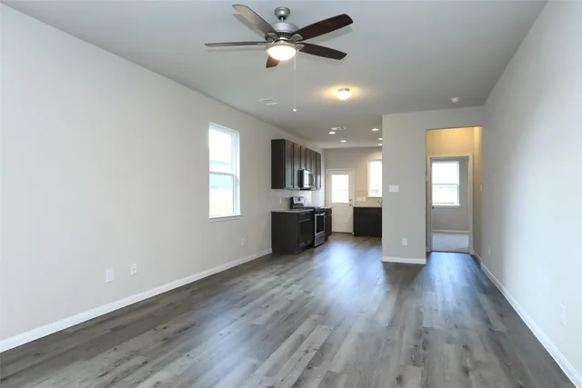 a view of an empty room and window with wooden floor