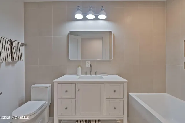 a bathroom with a toilet sink and mirror