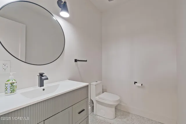 a bathroom with a sink mirror and toilet