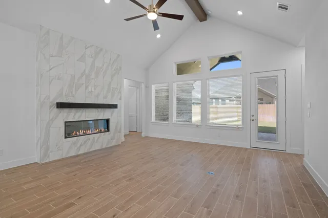 an empty room with windows and fireplace