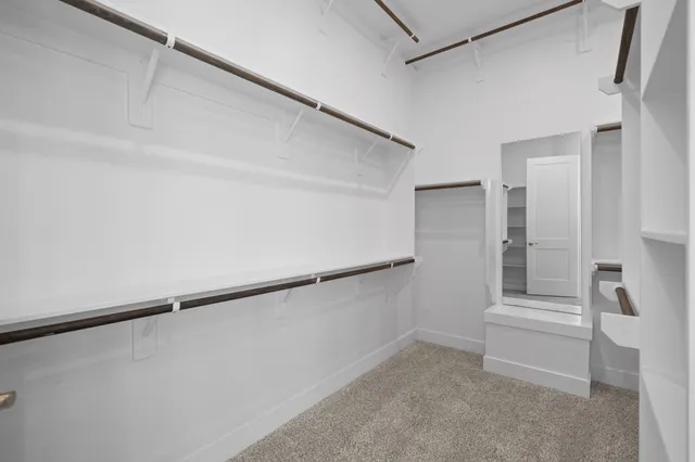 a view of walk in closet with empty racks