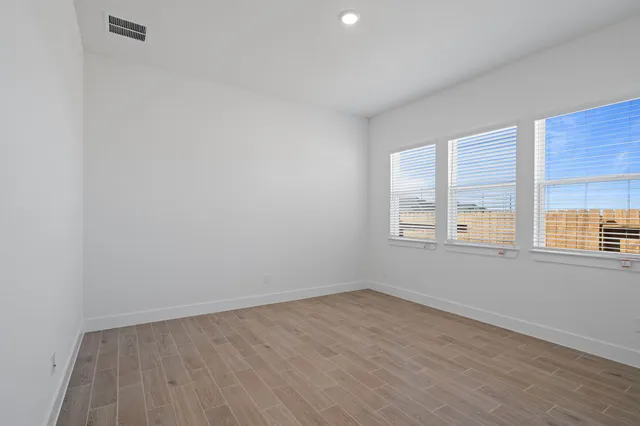 wooden floor in an empty room with a window
