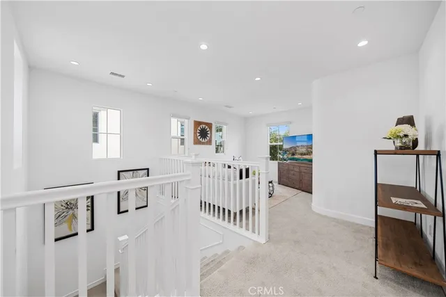 a living room with furniture a kitchen view and white cabinets