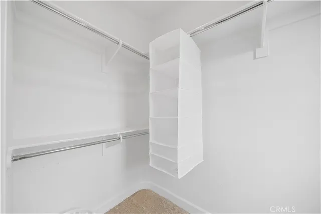 a view of walk in closet with empty racks