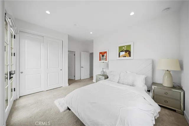 a bedroom with a bed and painting on the wall