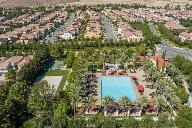 an aerial view of residential houses with outdoor space and trees