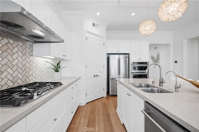 a kitchen with stainless steel appliances a sink a stove and refrigerator