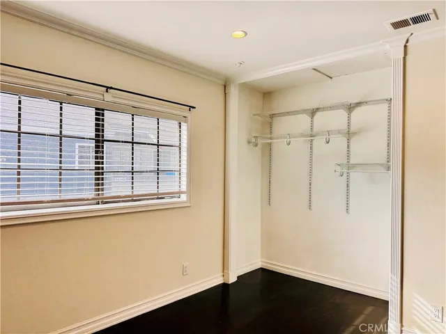 a view of a closet area with wooden floor
