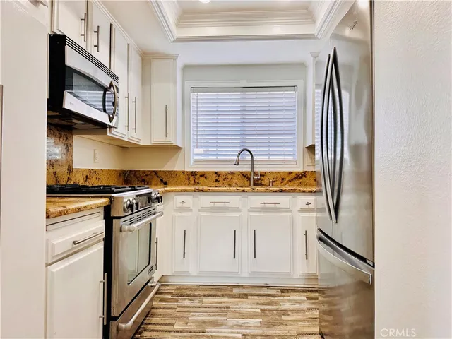 a kitchen with stainless steel appliances granite countertop a sink and a stove