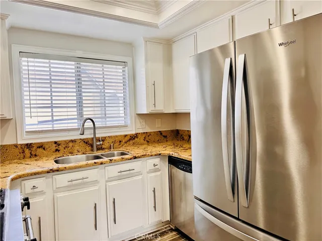 a kitchen with stainless steel appliances granite countertop a refrigerator and a sink