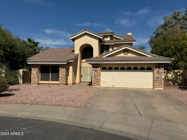 a front view of a house with a garage and a yard