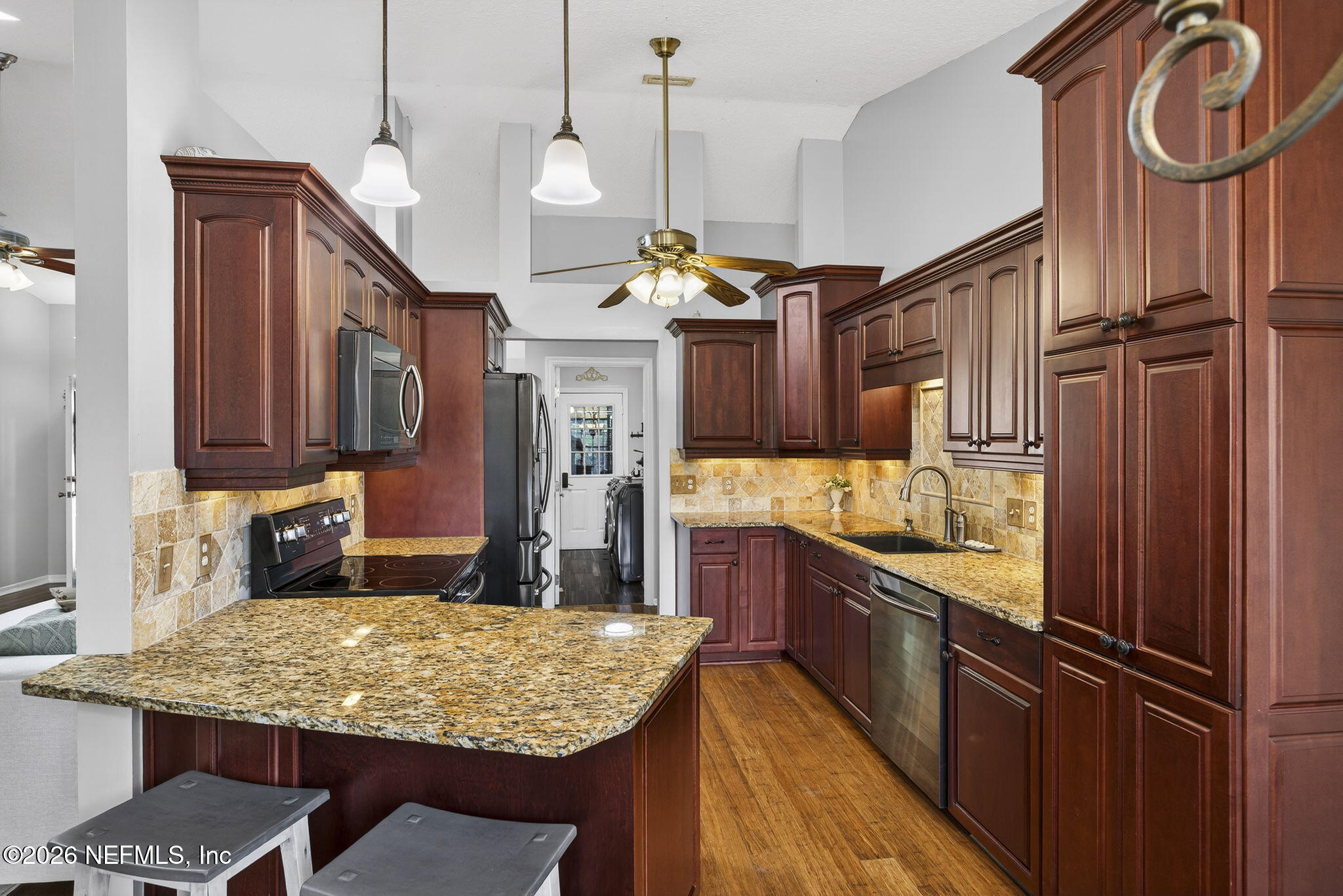 394 Cassandra Lane St. Augustine, FL 32086 - Photo 12 of 43 a kitchen with kitchen island granite countertop wooden cabinets and a stove
