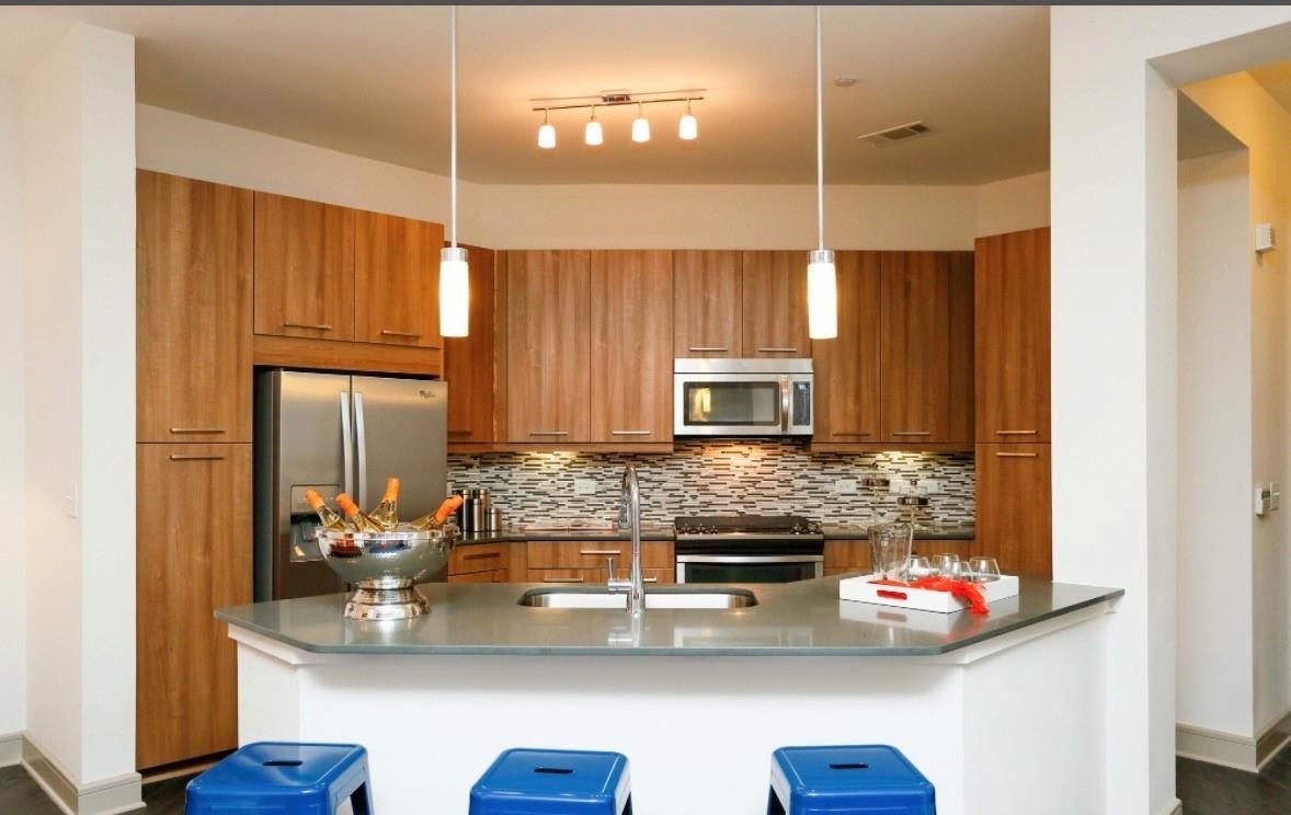 2111 Westheimer Road, Unit 1107 Houston, TX 77098 - Photo 2 of 10 a kitchen with stainless steel appliances a sink stove and microwave