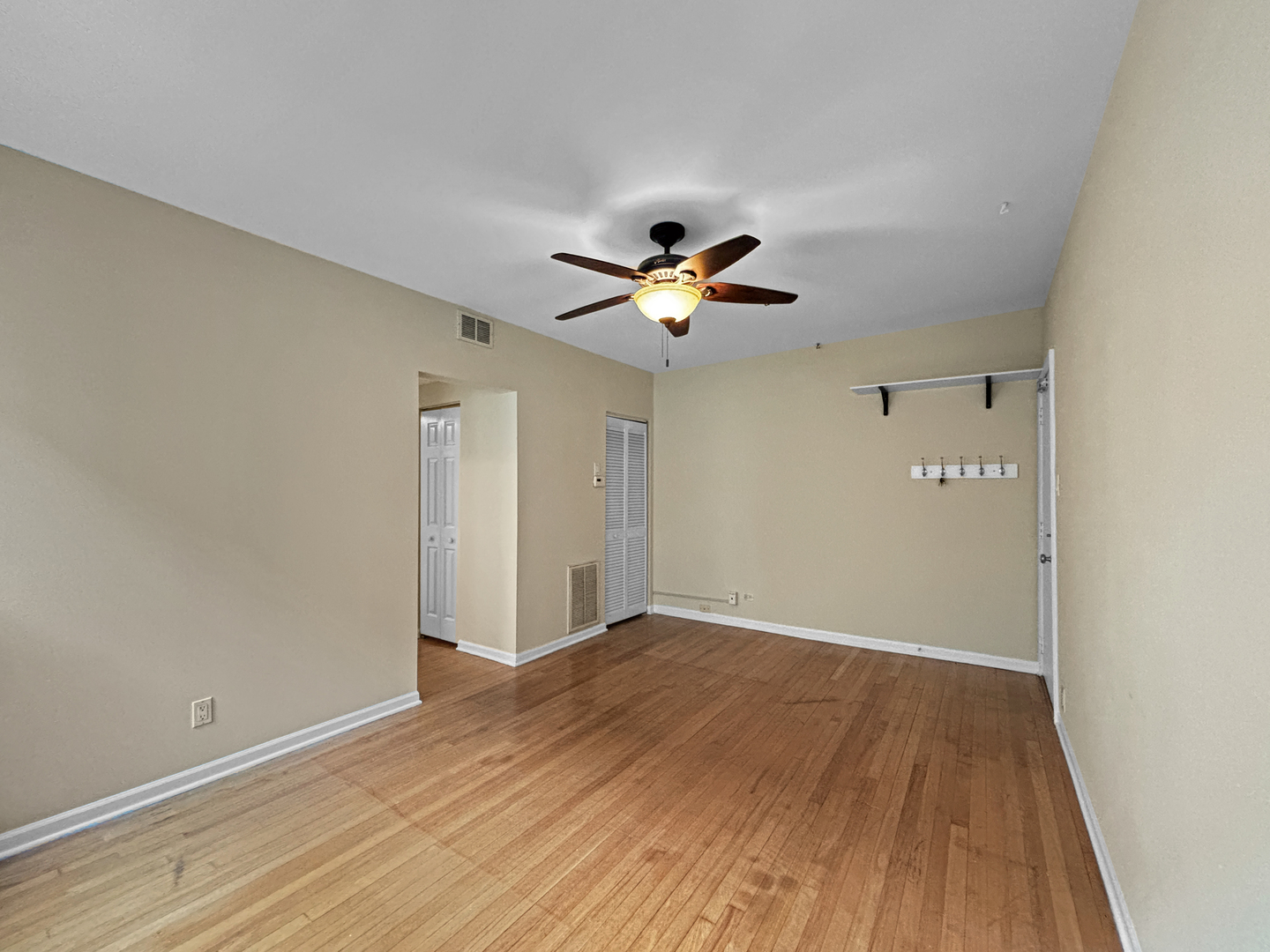 4240 North Clarendon Avenue, Unit 208S Chicago, IL 60613 - Photo 5 of 14 a view of an empty room with wooden floor