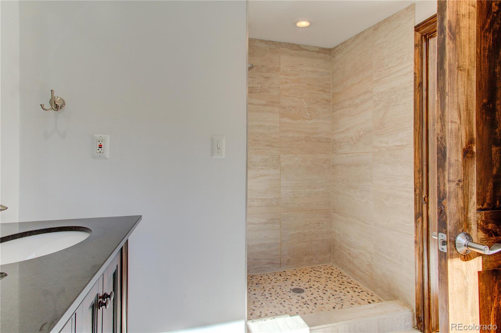 30305 Lone Spruce Road Evergreen, CO 80439 - Photo 29 of 40 a bathroom with a sink and a shower