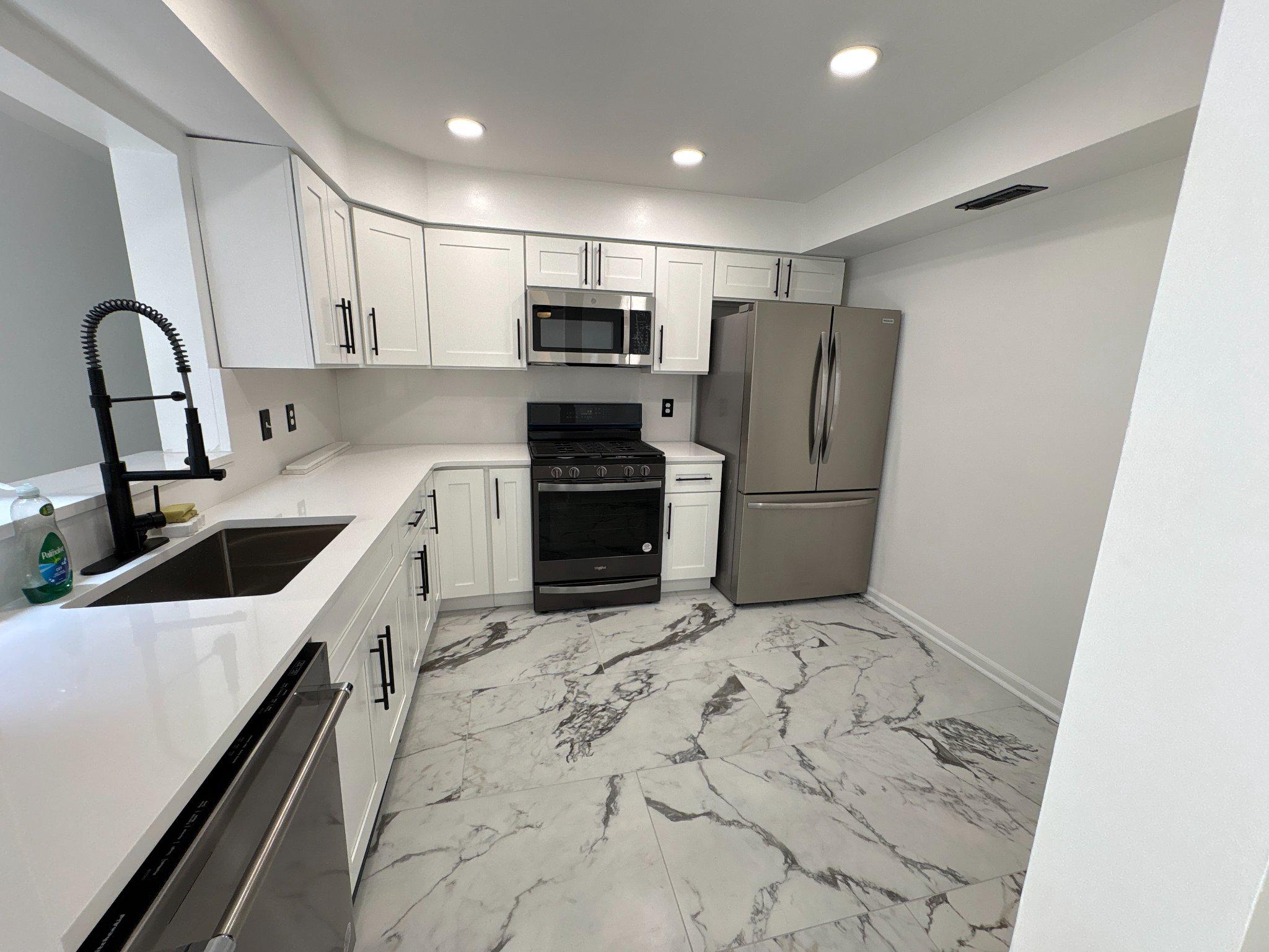 72304 Delaire Landing Road, Unit 304 Philadelphia, PA 19114 - Photo 16 of 56 Sleek modern kitchen with marble floors.
