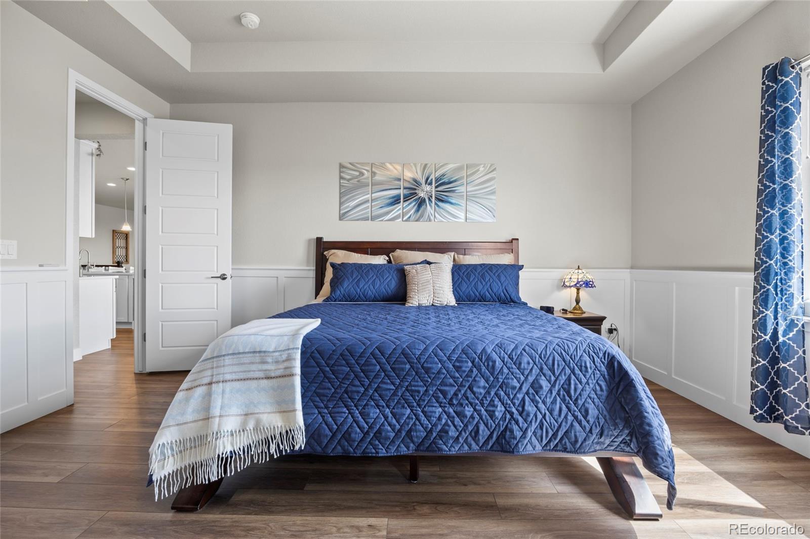 164 Rockingham Circle Castle Pines, CO 80108 - Photo 12 of 43 a bedroom with a bed and wooden floor